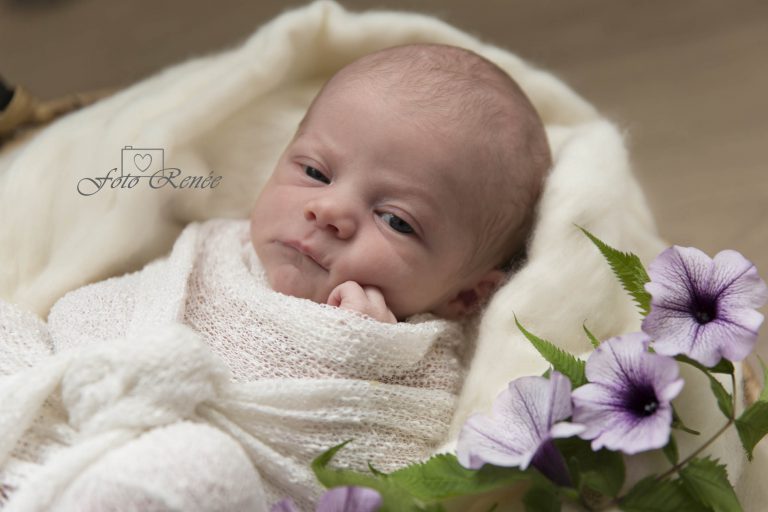 Baby in wit deken met bloem